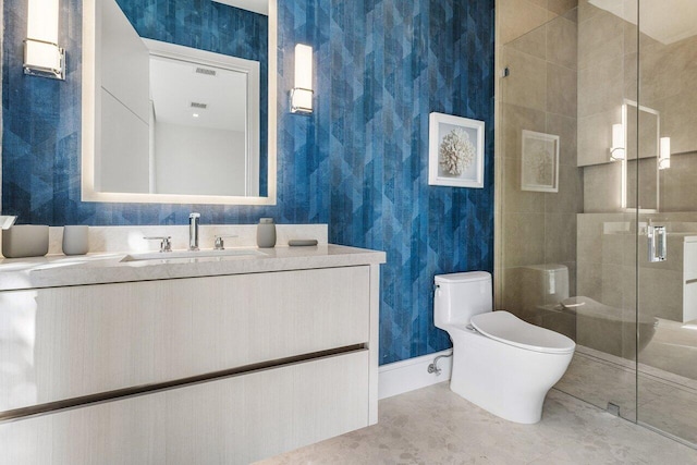 bathroom featuring a shower stall, vanity, toilet, and wallpapered walls