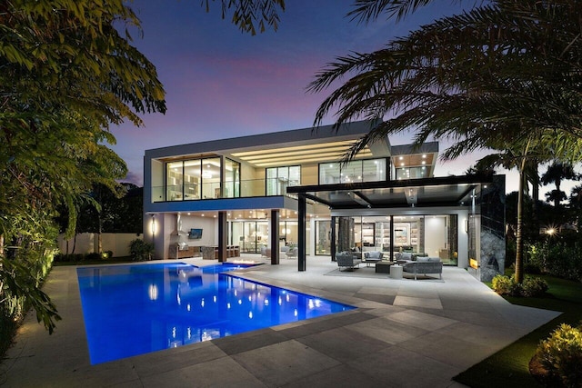 rear view of house featuring a balcony, an outdoor hangout area, fence, an outdoor pool, and a patio area