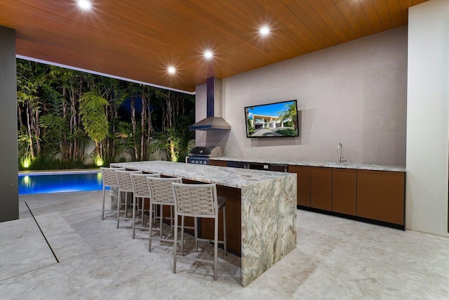 bar featuring wood ceiling, wet bar, wall chimney range hood, a sink, and recessed lighting