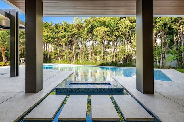 view of swimming pool with a patio and a pool with connected hot tub