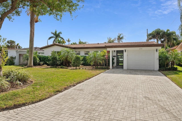 single story home featuring a front lawn and a garage