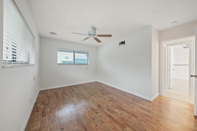 spare room featuring ceiling fan, hardwood / wood-style flooring, and a textured ceiling