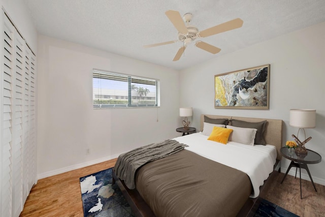 bedroom featuring ceiling fan, a textured ceiling, and light wood-type flooring