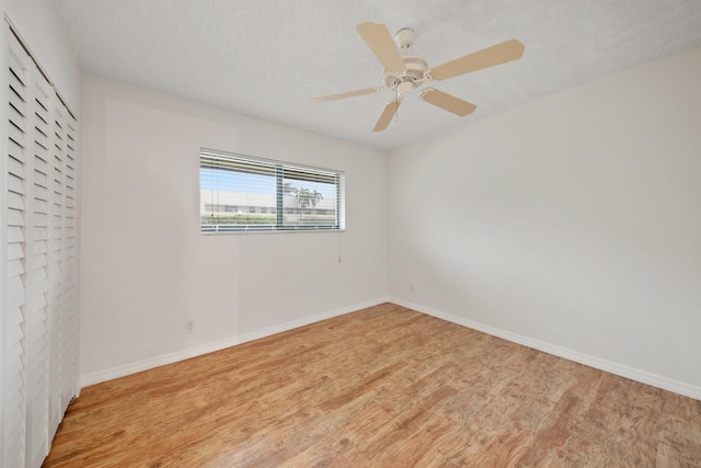 spare room featuring ceiling fan, a textured ceiling, and light wood-type flooring