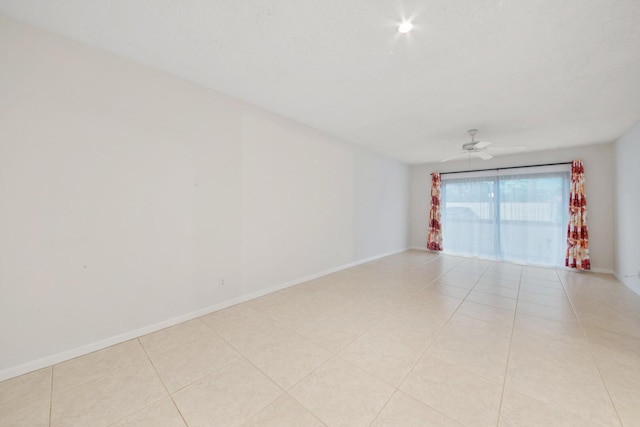 tiled spare room featuring ceiling fan