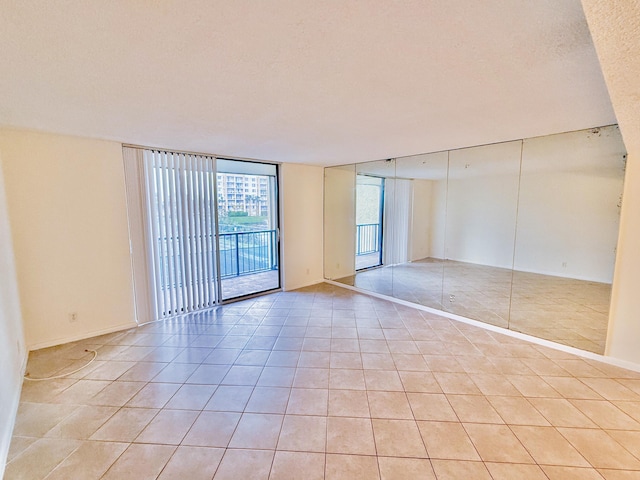 tiled spare room featuring expansive windows