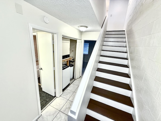 stairs featuring a textured ceiling