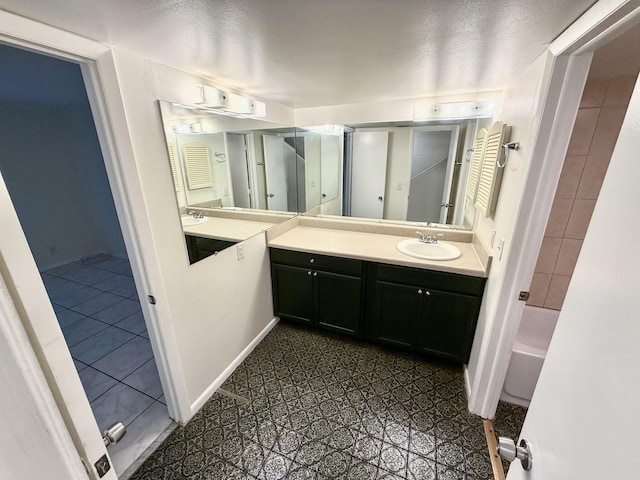 bathroom featuring vanity, a textured ceiling, and tiled shower / bath combo