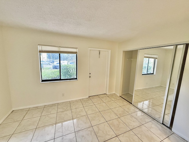 unfurnished room with a healthy amount of sunlight and a textured ceiling