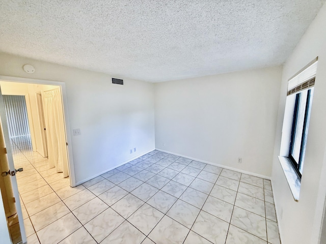 unfurnished room with a textured ceiling