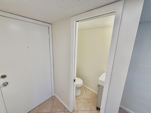 bathroom featuring tile patterned floors, toilet, and a textured ceiling