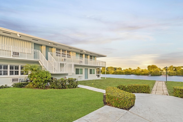 exterior space with a water view and a lawn