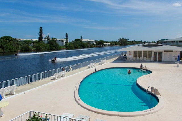 view of swimming pool featuring a patio area and a water view