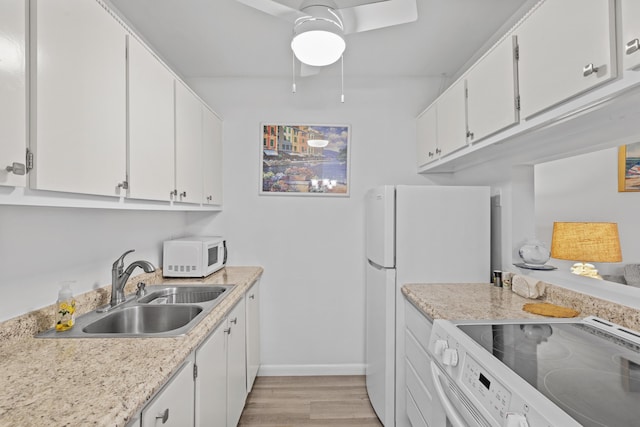 kitchen featuring light wood-type flooring, white appliances, ceiling fan, sink, and white cabinetry