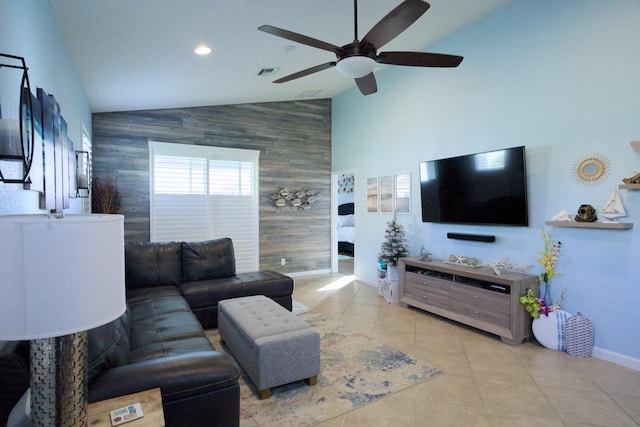 living room with ceiling fan, light tile patterned floors, and vaulted ceiling