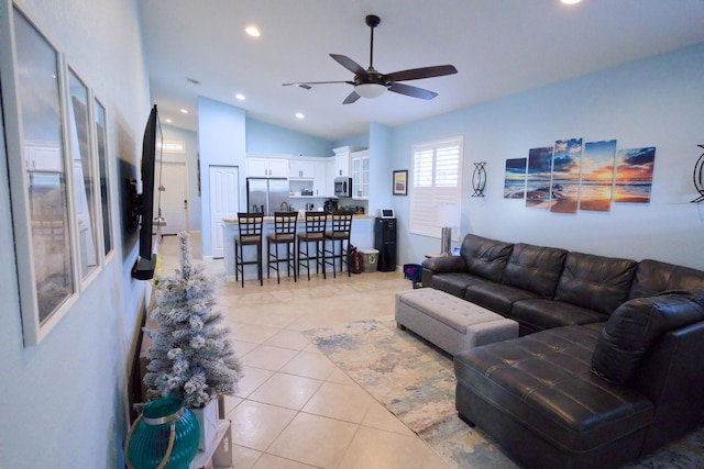 tiled living room with ceiling fan and vaulted ceiling