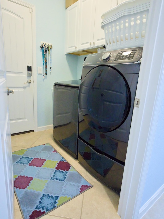 washroom featuring cabinets, light tile patterned floors, and independent washer and dryer