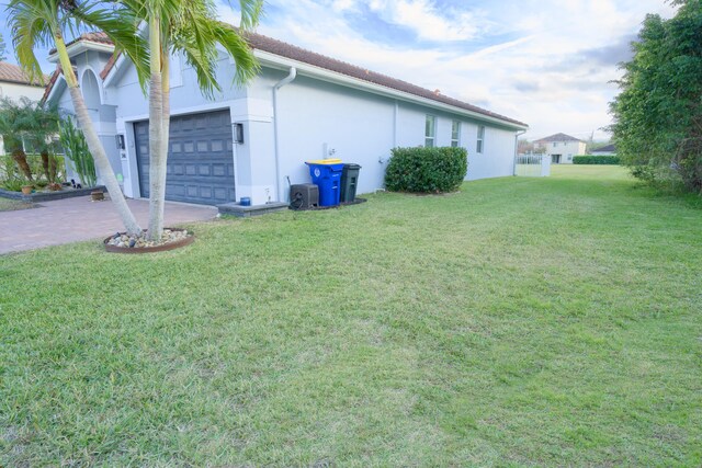 view of home's exterior with a lawn and a garage