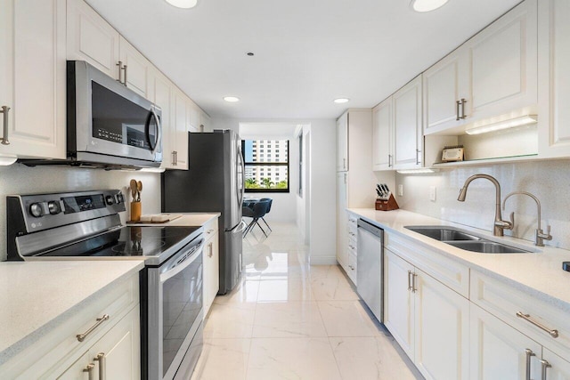 kitchen featuring white cabinets, stainless steel appliances, and sink