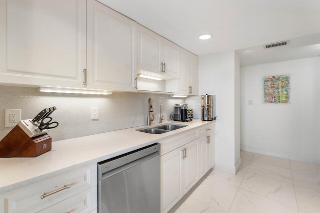 kitchen with stainless steel dishwasher, white cabinets, sink, and tasteful backsplash