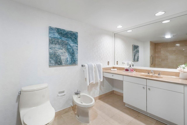 bathroom featuring tile patterned floors, vanity, toilet, and a bidet