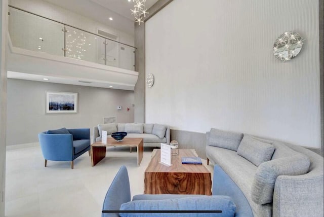 living room with a towering ceiling and a chandelier