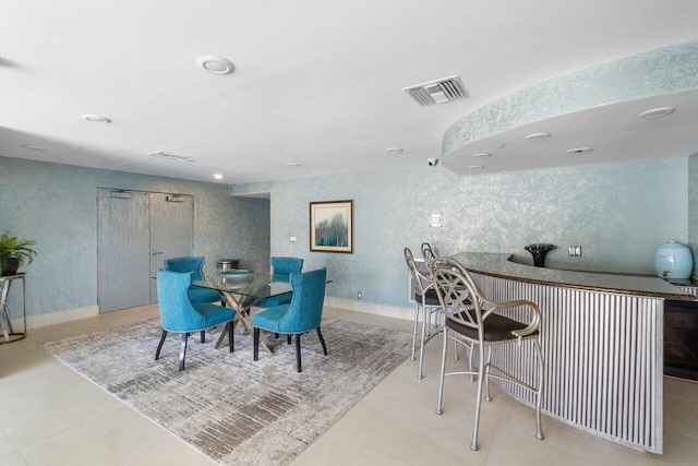 dining room with bar and light tile patterned floors