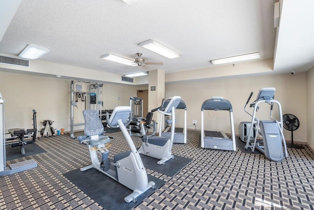 gym with ceiling fan and a textured ceiling