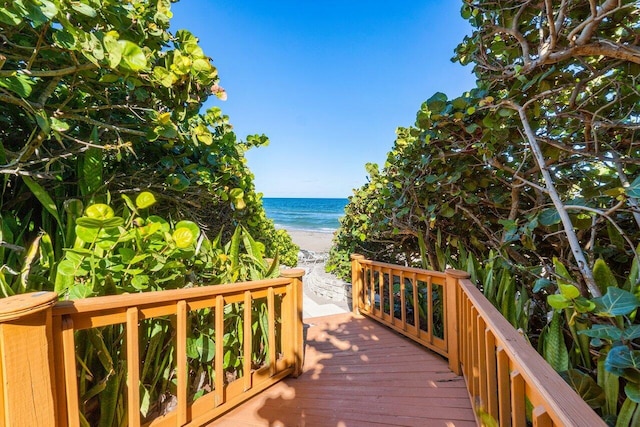 deck featuring a water view and a beach view