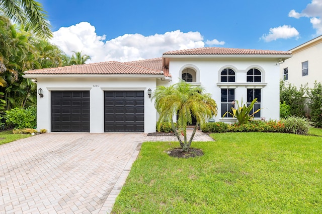 mediterranean / spanish house with a front yard and a garage