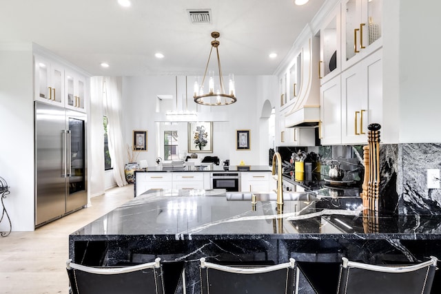 kitchen featuring sink, hanging light fixtures, decorative backsplash, white cabinetry, and stainless steel appliances