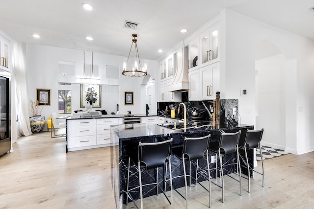 kitchen with a kitchen breakfast bar, kitchen peninsula, white cabinetry, and decorative light fixtures