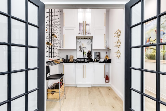 bar featuring white cabinetry and light wood-type flooring