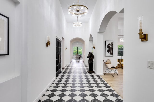 hallway featuring a high ceiling and a notable chandelier