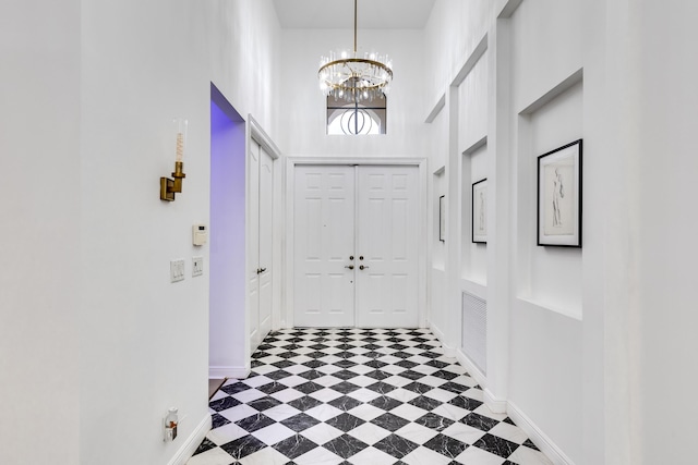 interior space with a notable chandelier and a towering ceiling