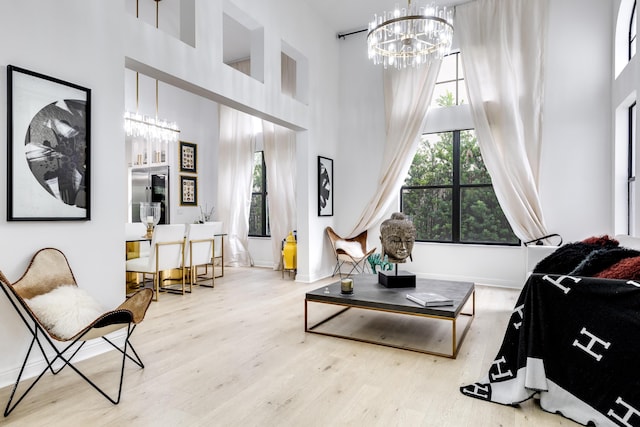 interior space featuring a chandelier, a high ceiling, and light wood-type flooring