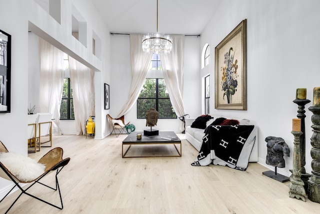 living area featuring a notable chandelier, a healthy amount of sunlight, and light hardwood / wood-style flooring