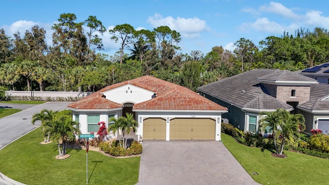 mediterranean / spanish-style house with a garage and a front lawn