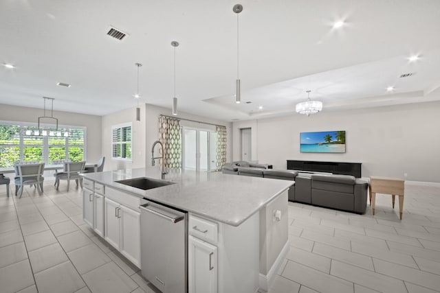 kitchen featuring white cabinetry, stainless steel dishwasher, a kitchen island with sink, and sink