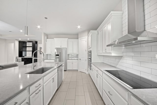 kitchen featuring white cabinets, wall chimney exhaust hood, sink, and stainless steel appliances