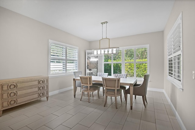 tiled dining space featuring an inviting chandelier