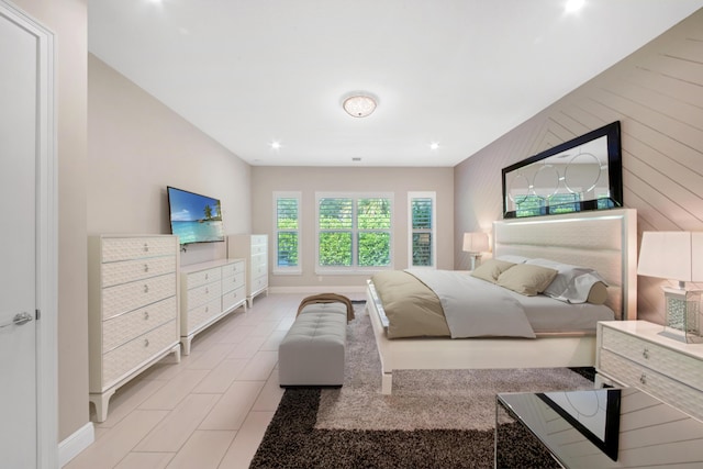 bedroom with wood walls and light tile patterned floors