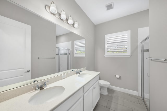 bathroom with tile patterned flooring, vanity, toilet, and walk in shower