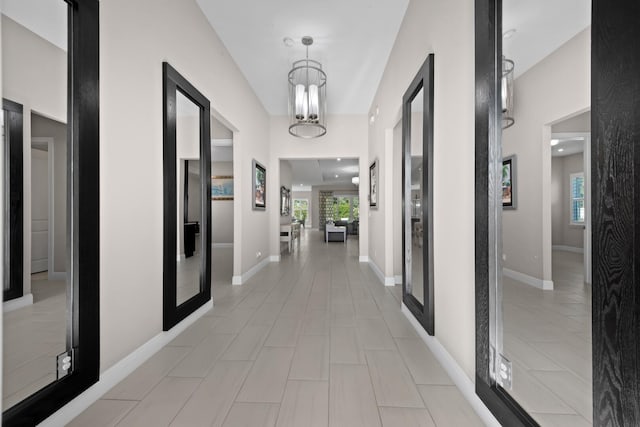 hallway featuring a chandelier and light tile patterned flooring