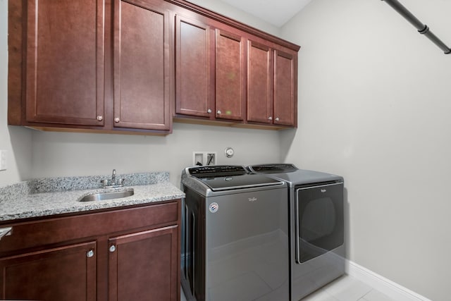 washroom featuring cabinets, separate washer and dryer, sink, and light tile patterned floors