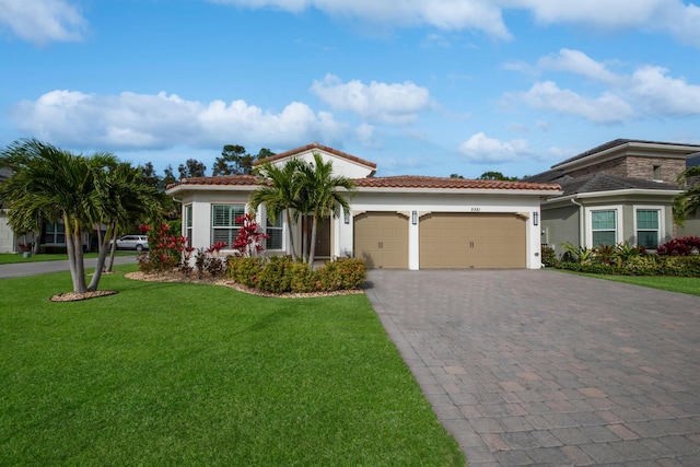 mediterranean / spanish-style home featuring a front lawn and a garage