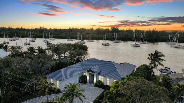 aerial view at dusk featuring a water view