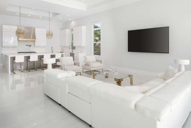 tiled living room with a notable chandelier, sink, and a tray ceiling