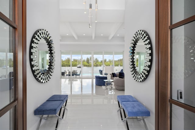 hallway featuring beamed ceiling and a water view