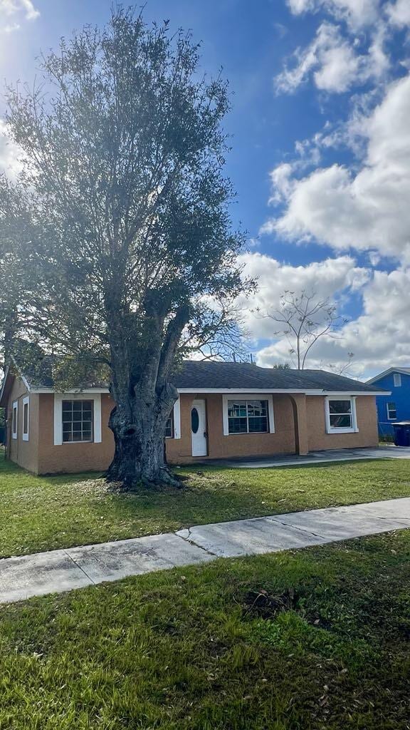 single story home with a front lawn